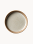 Widok z góry na okrągły ceramiczny talerz z nakrapianym, jasnoszarym szkliwionym wnętrzem i grubym, nieszkliwionym rantem z naturalnej terakoty.